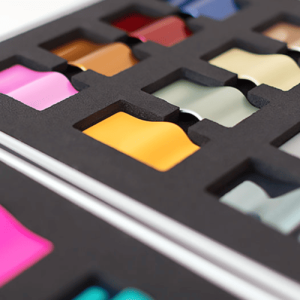 Närbild på färgprovskollektion från Berlac med formsprutade, metalliserade och lackerade plastplattor i 31 olika trendkulörer, producerade av AMB.